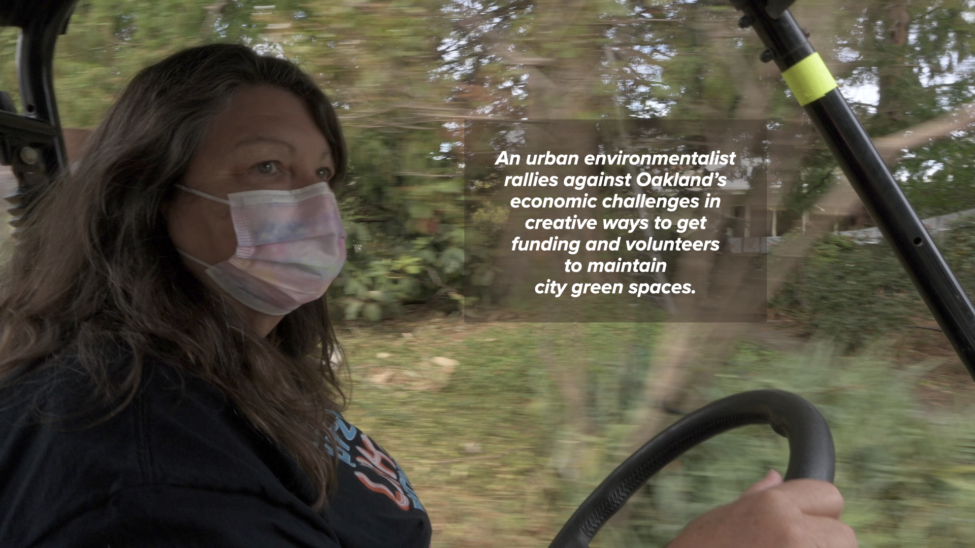 Woman wearing mask driving a golf cart through a botanical garden